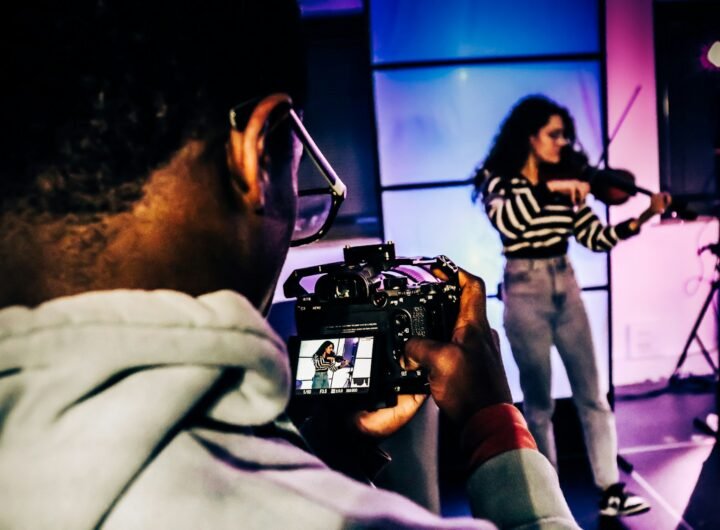 a woman holding a camera in front of a man