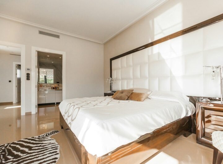 brown wooden bed frame with white cover beside brown wooden nightstand