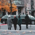 man in green coat walking on pedestrian lane during daytime