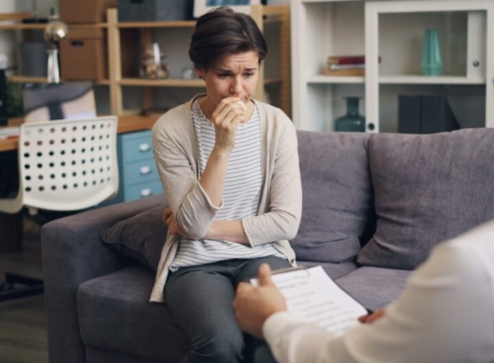 a woman sitting on a couch talking to a man