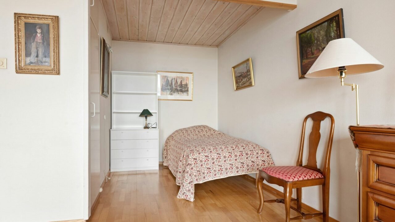 A bedroom with a bed and a chair in it