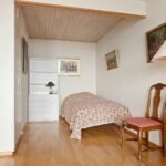 A bedroom with a bed and a chair in it