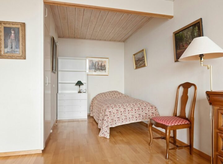 A bedroom with a bed and a chair in it