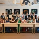 a group of people sitting at a long table