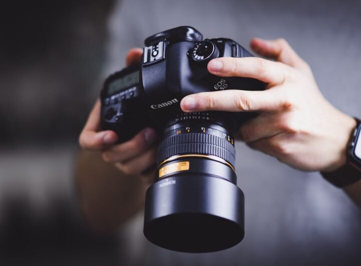 person holding Canon DSLR camera