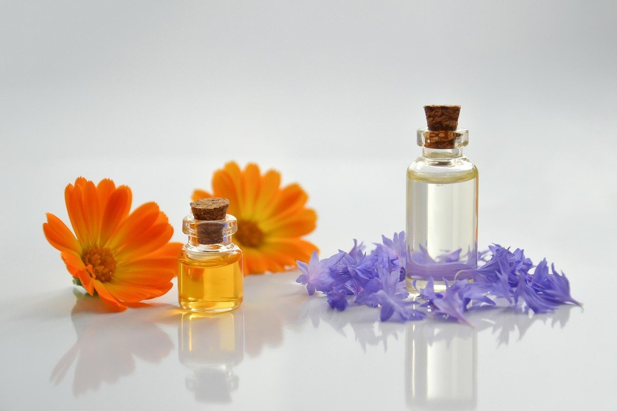 Huiles essentielles de calendula et lavande dans des fioles sur une surface blanche