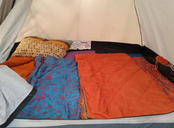 L'intérieur d'une tente avec coussin, couvertures et sac de couchage